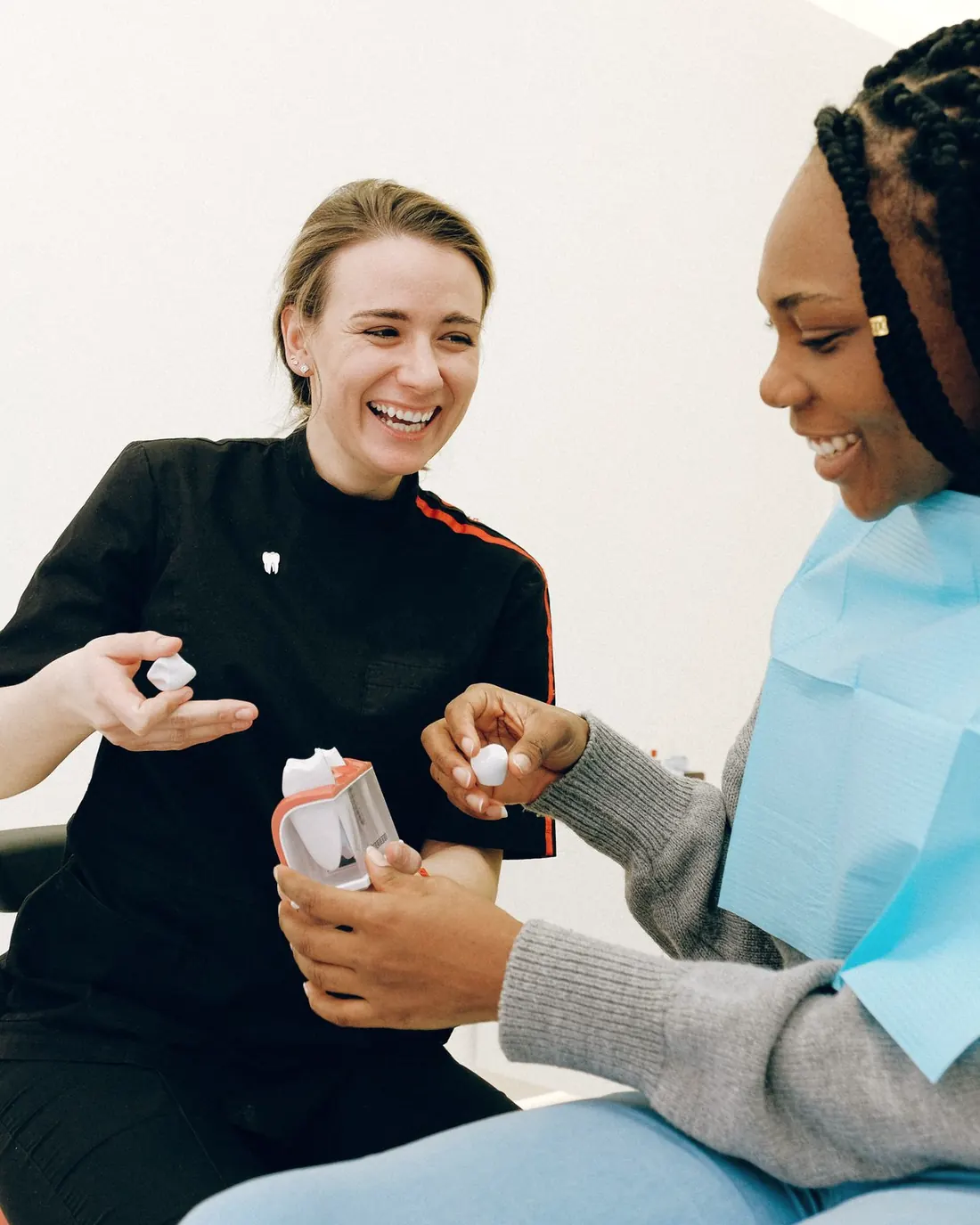 A dentist and patient talking and laughing in the dental chair