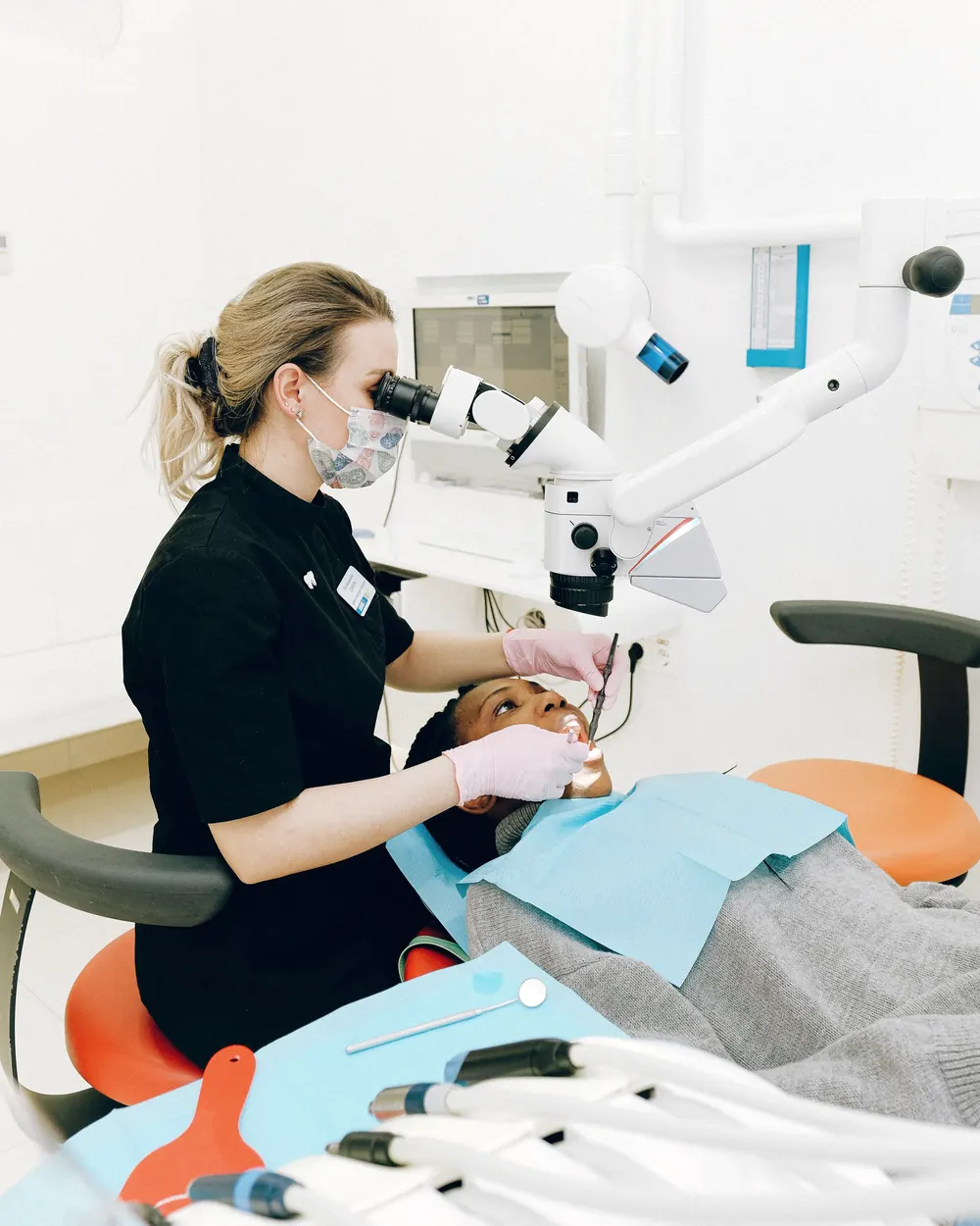A dentist using a dental microscope while treating a patient